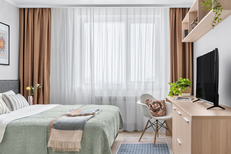 Ыңғайлы жатын бөлме үлкен терезе мен теледидармен