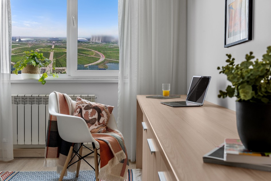 Терезе алдында табиғат көрінісіне қарап отырып жұмыс істейтін орында ноутбукпен