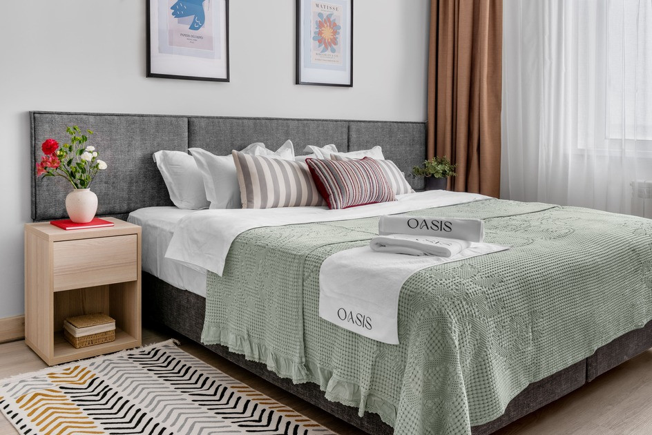 Комфортты төсек және әдемі жастықтары бар жатын бөлме