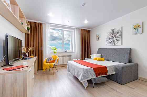 Современный интерьер с кроватью и телевизором в комнате с яркими акцентами