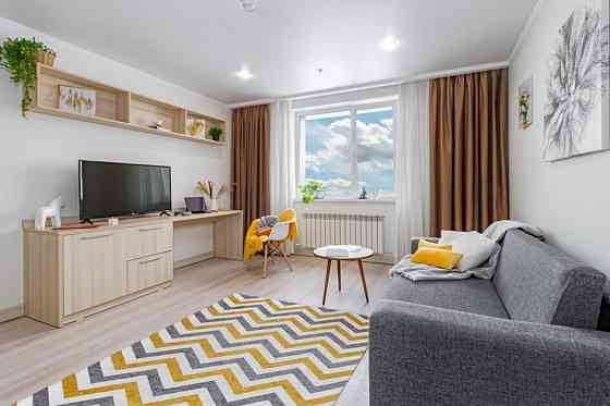 Современный интерьер с кроватью и телевизором в комнате с яркими акцентами