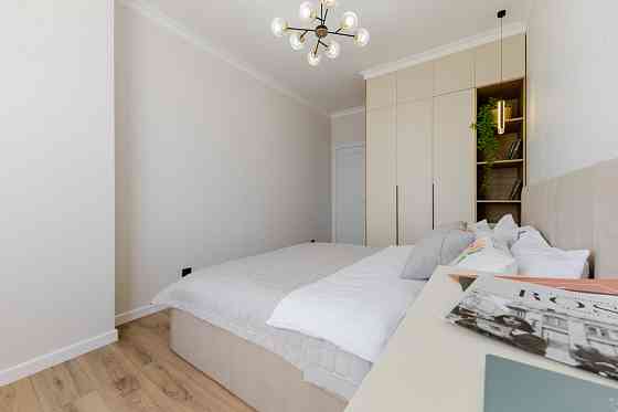 Столик с книгами и пледом на белом столе рядом с электроприбором