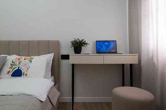 Столик с книгами и пледом на белом столе рядом с электроприбором