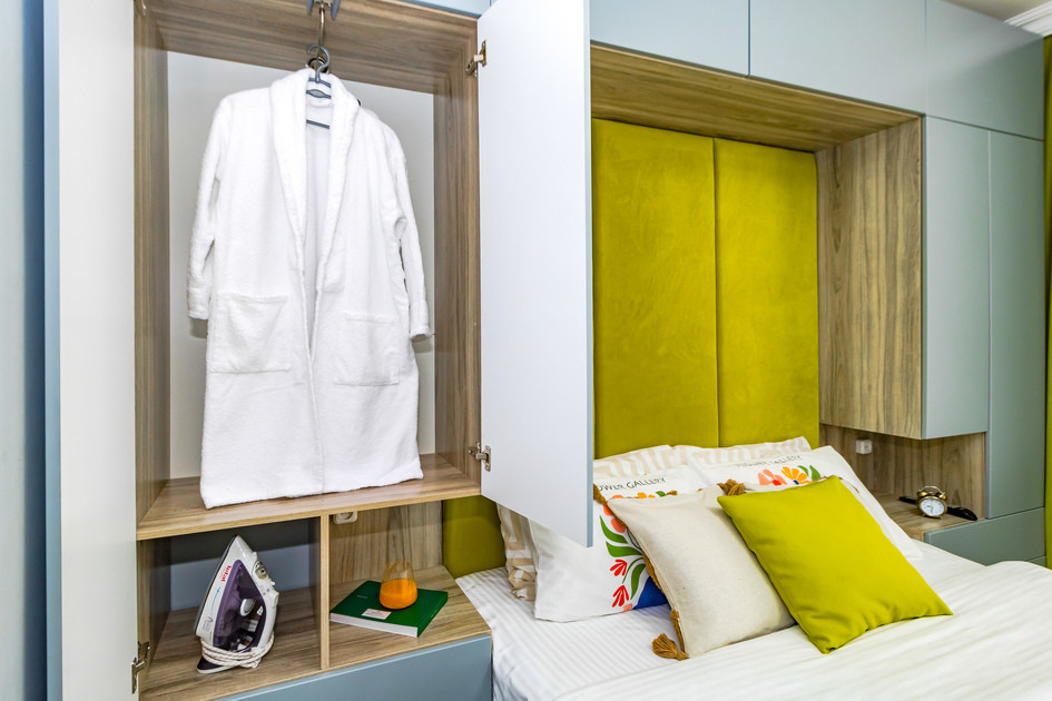 Открытый шкаф в спальне с халатом и предметами интерьера