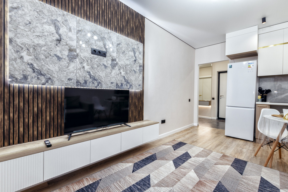 Гостиная с телевизором на стене и стильной отделкой