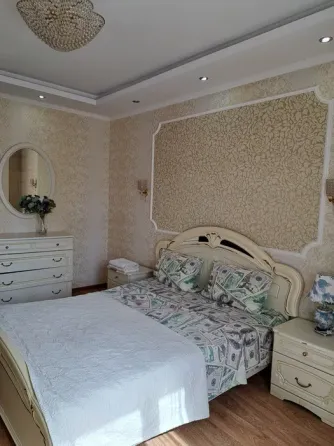 Кровать с постельным бельем в стиле долларов в спальне с хрустальной люстрой