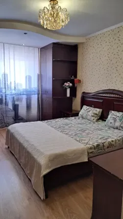 Кровать с постельным бельем в стиле долларов в спальне с хрустальной люстрой