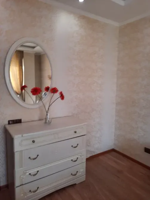 Комната с зеркалом и вазой из цветов