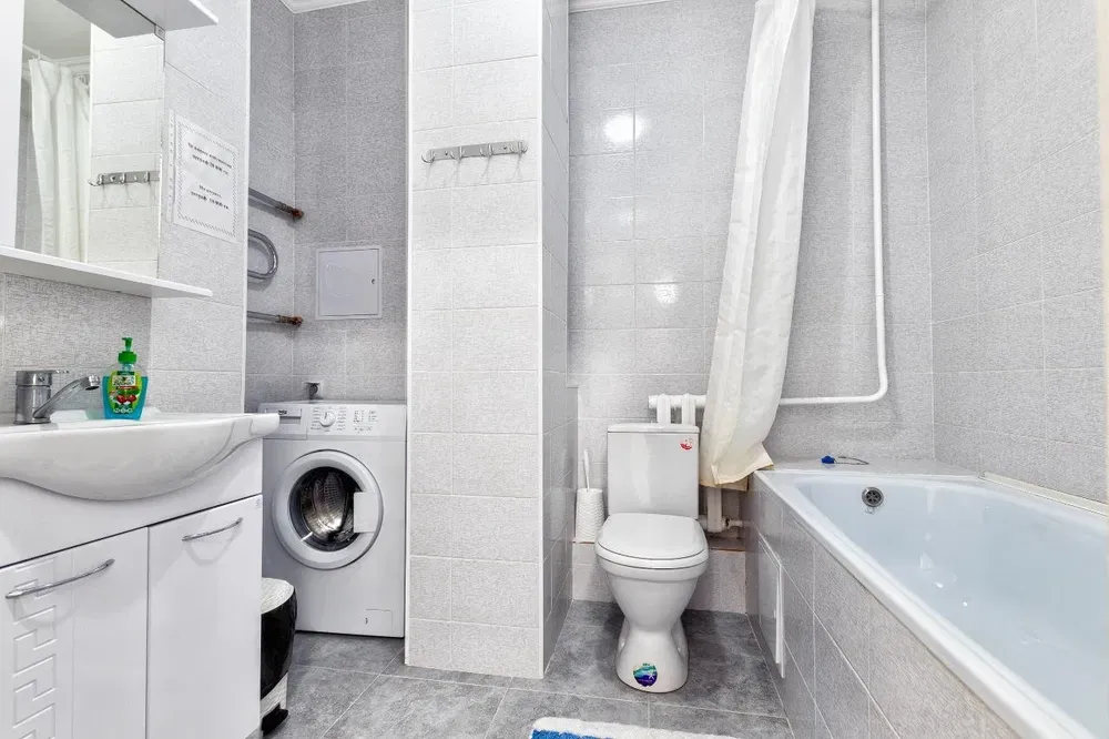 Современная ванная комната с стиральной машиной и ванной