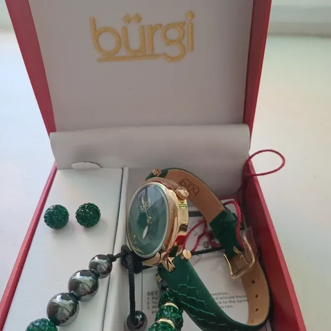 Жасыл циферблатты сағат, моншақтан білезік және сырға оралған