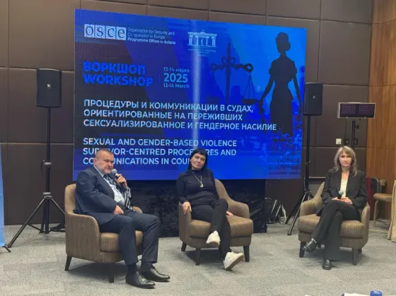 Әйелдің үстелде отырып, ноутбукке қарап отырған сәті