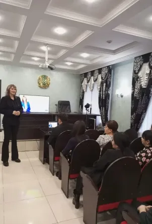 Әйелдің үстелде отырып, ноутбукке қарап отырған сәті