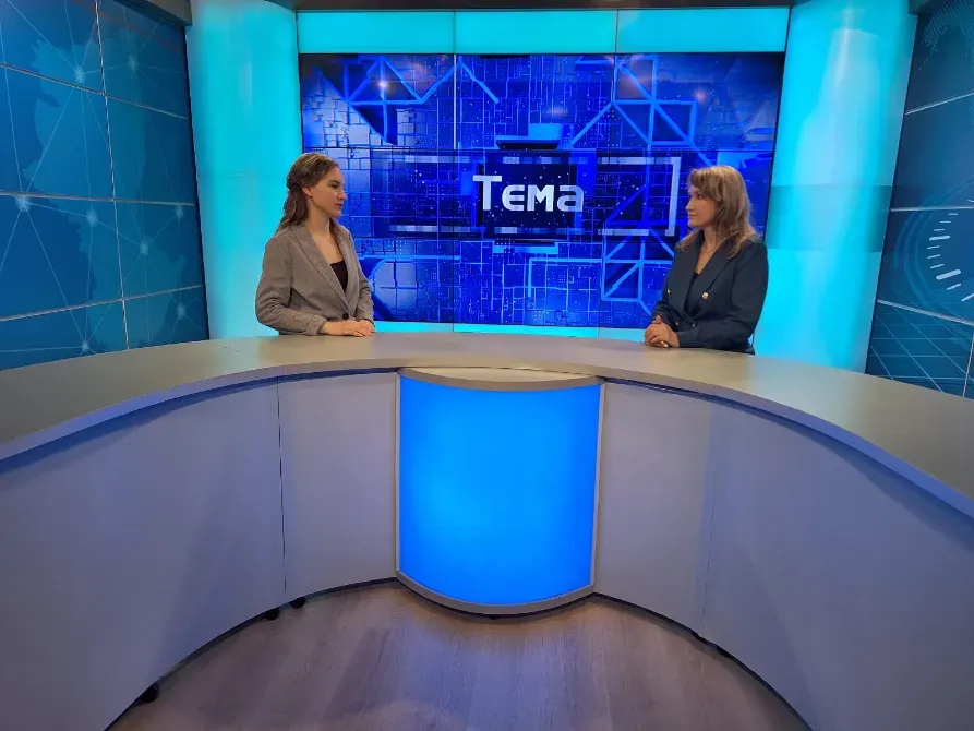 Телевидениеде ағымдағы тақырыпты талқылап жатқан екі адам