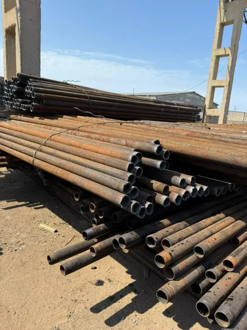 Группы стальных труб с ржавчиной, хранящиеся на складе