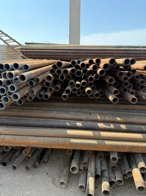 Упакованные стальные трубы на строительной площадке под открытым небом