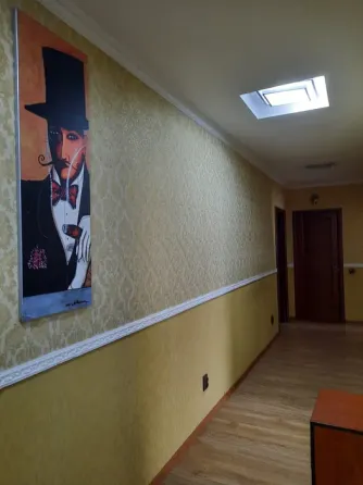 Спальня с желтым покрывалом и диваном, украшенная картиной