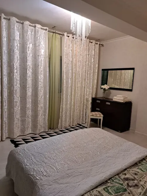 Ұйықтайтын бөлме перделер мен айна комодпен