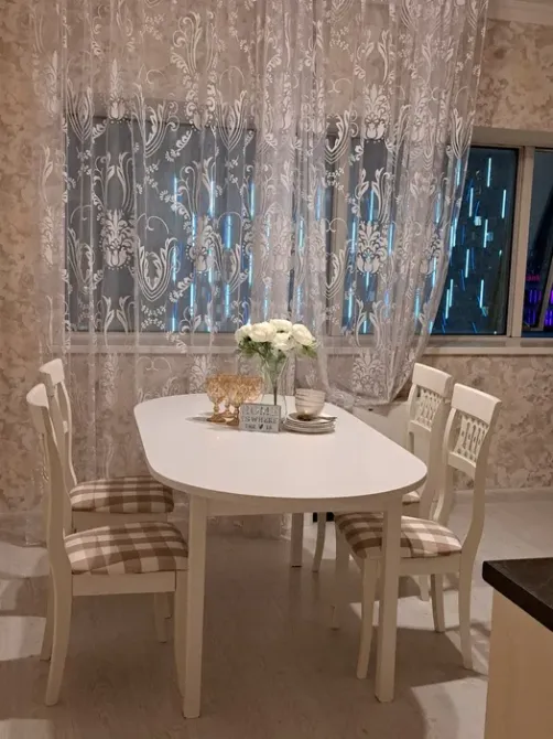 Терезе жанындағы обед үстелі мөлдір перделермен