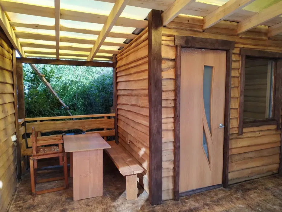 Веранда с обеденной зоной и входной дверью, ведущей в дом