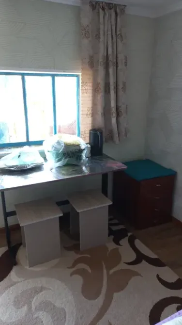 Терезе жанындағы үстел және орындықтармен жабдықталған жылы бұрыш