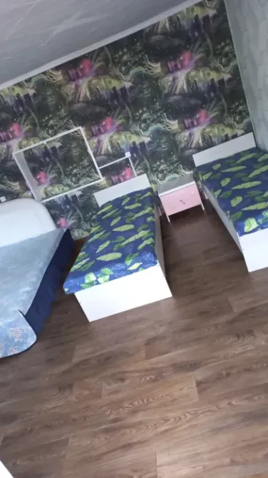 Комната с двумя односпальными кроватями и одной двуспальной кроватью, оформленная в зеленых тонах