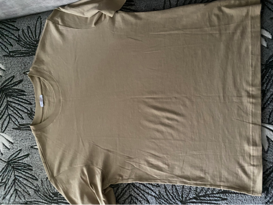 Футболка бежевого цвета на плоской поверхности