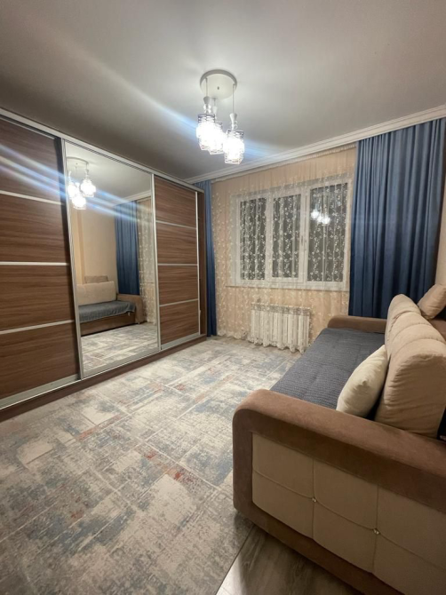 Заманауи жатын бөлмесі үлкен айна шкафымен, диванмен және ашық түстермен