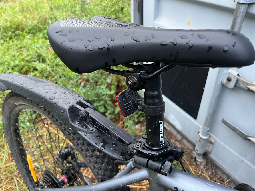 Седло велосипеда, капли воды на поверхности, фон контейнера