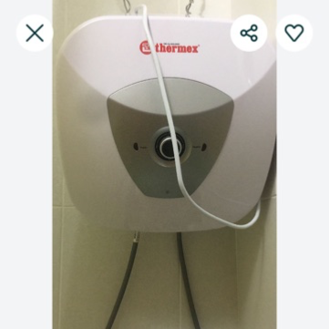 Водонагреватель Thermex, установленный на стене, с видимой проводкой и трубами