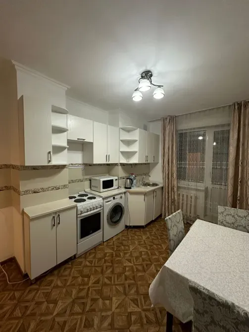 Кухня с обеденным столом, плитой и холодильником