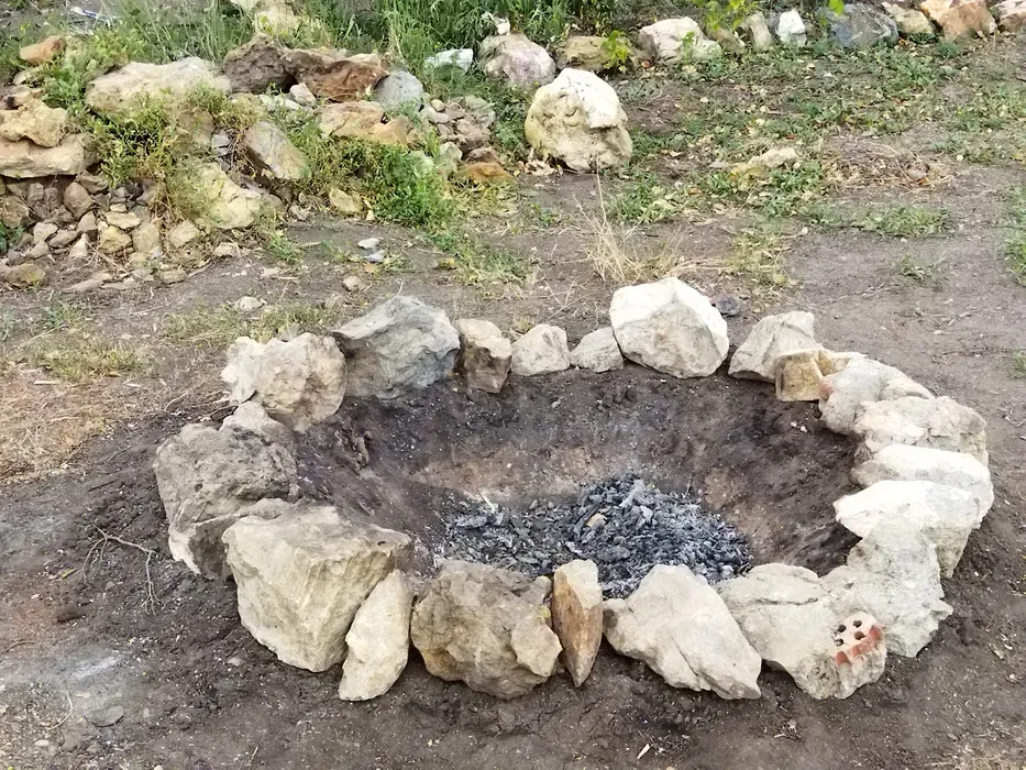 Костровище окруженное камнями на открытом воздухе