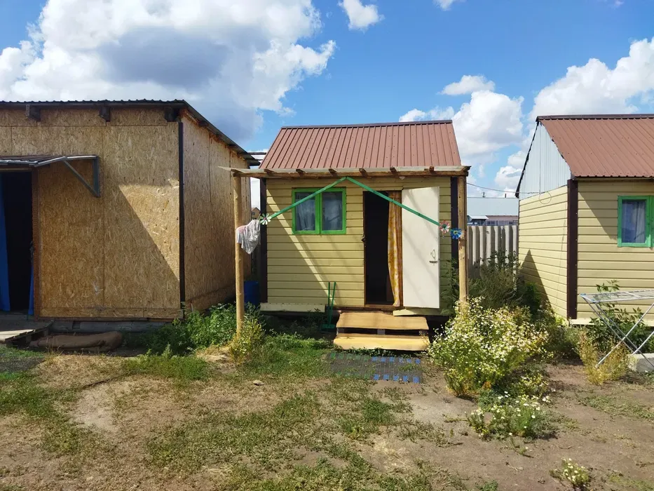 Коттеджи на отдыхе с деревянными стенами и крышей, окруженные зеленью