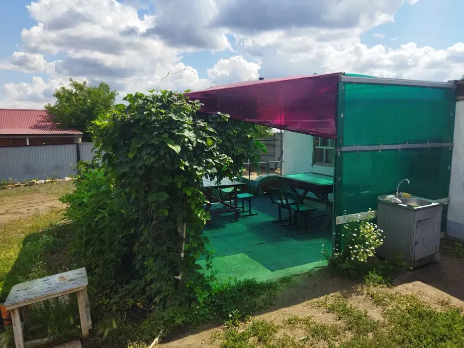 Зона для отдыха на свежем воздухе с столами и крышей из цветных материалов