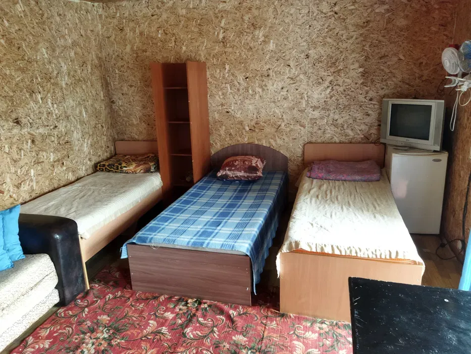 Спальня с тремя кроватями и шкафом, отделка из древесных материалов