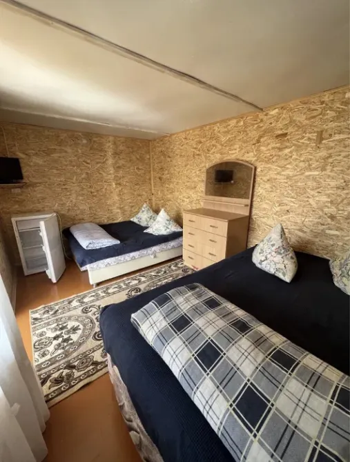 Комната с тремя кроватями, шкафом и телевизором