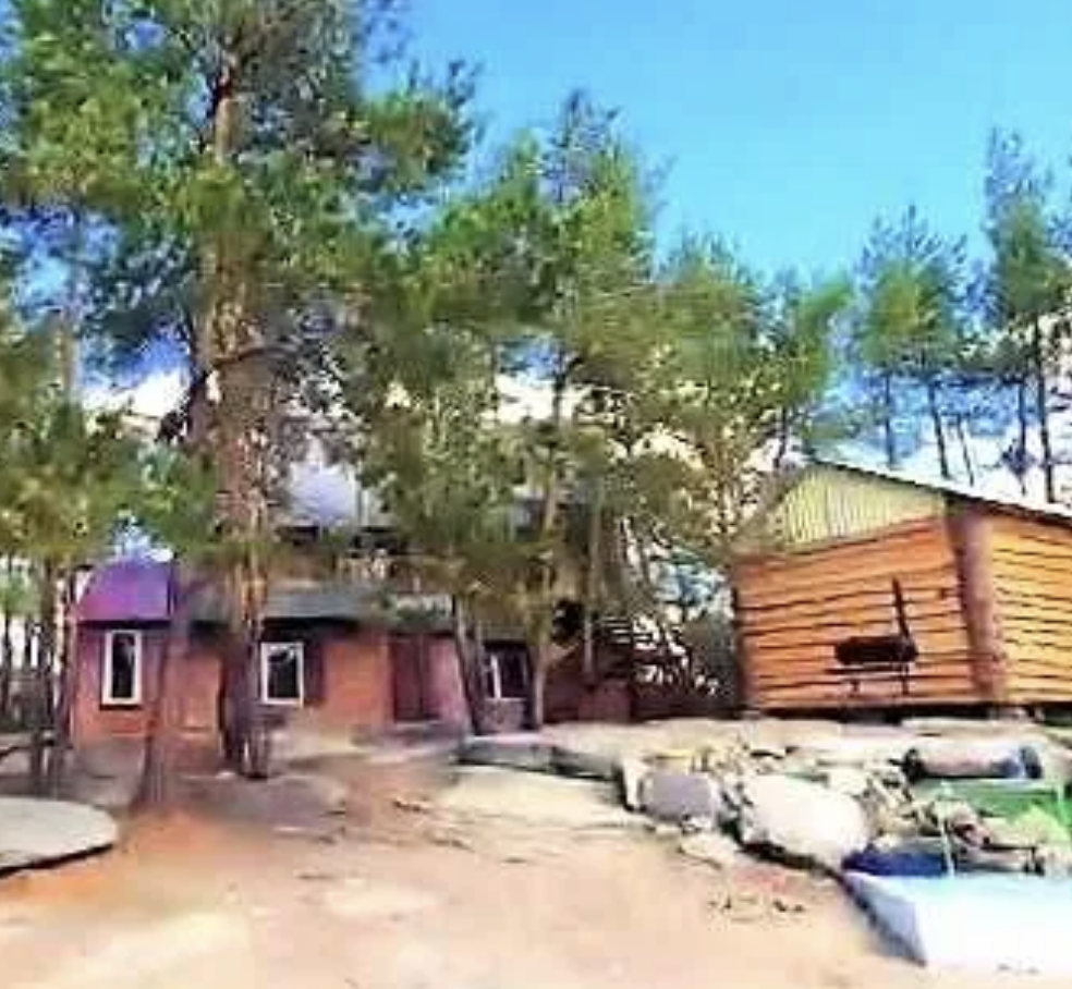 Дом на природе с деревянными постройками и зелеными деревьями