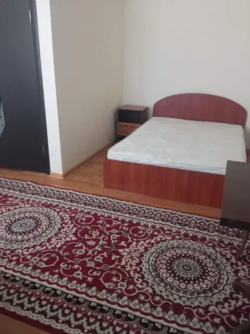 Спальня с пустой кроватью и ковром