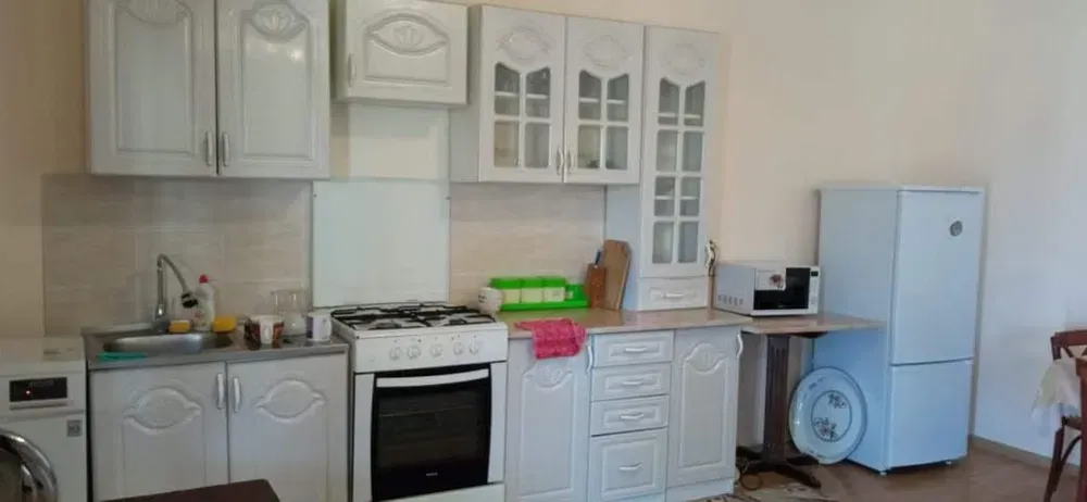 Современная кухня с белыми шкафами и техникой