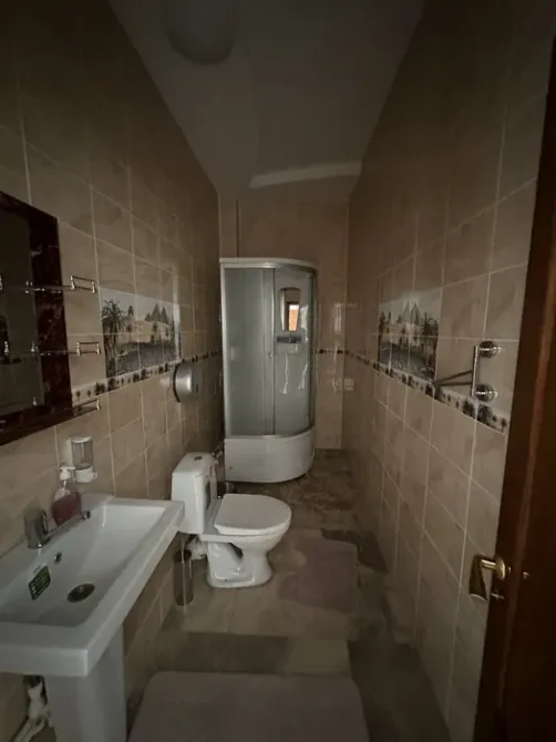 Уютная ванная комната с душевой кабиной и сантехникой