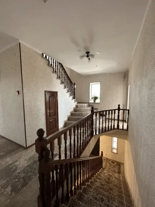 Лестничная площадка с деревянным перилами и окнами