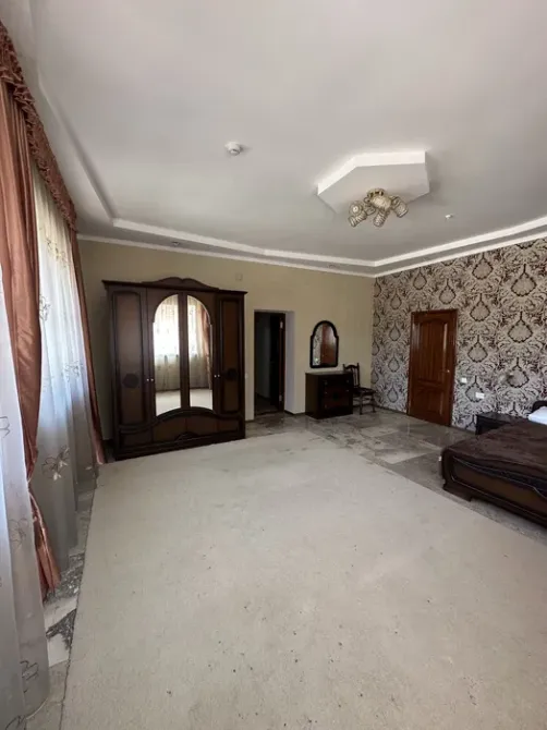 Просторная комната с зеркальным шкафом и красивыми обоями