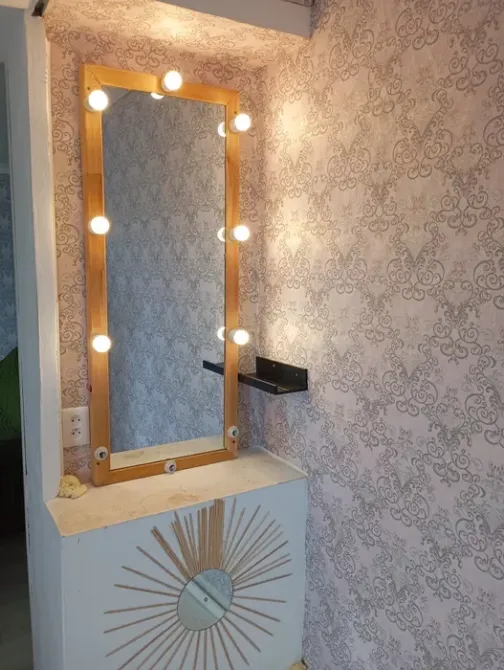 Қабырғада шамдары бар айна