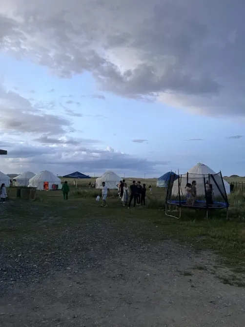 Люди на отдыхе возле юрт и батутов