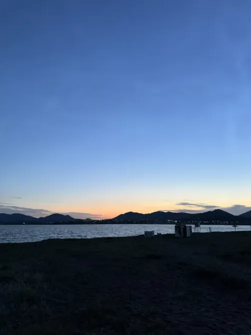 Вечерний вид на озеро с горами на горизонте