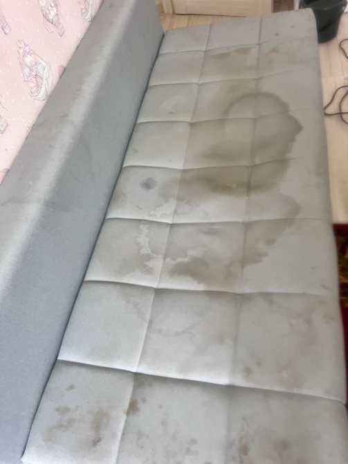 Серый диван с пятнами на ткани