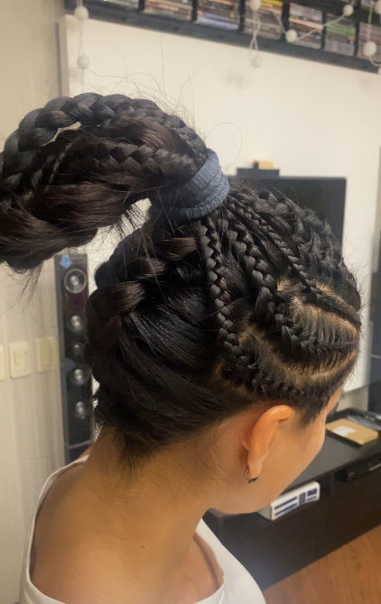 Қара шаштардағы косалармен жоғары жинақы шаш үлгісі.