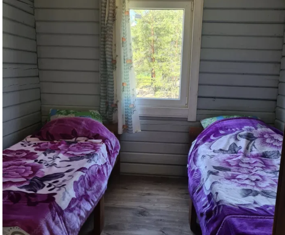 Спальня с двумя односпальными кроватями и окнами