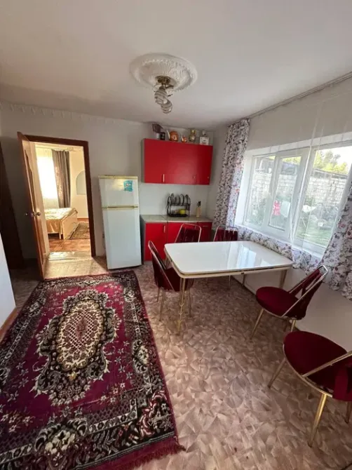 Кухня с холодильником и красными шкафами