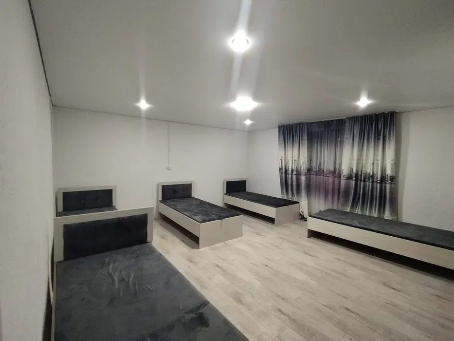 Комната с несколькими кроватями и окнами