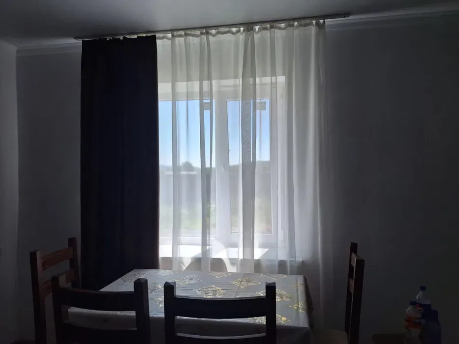 Обеденный стол с окнами, занавесками и стульями